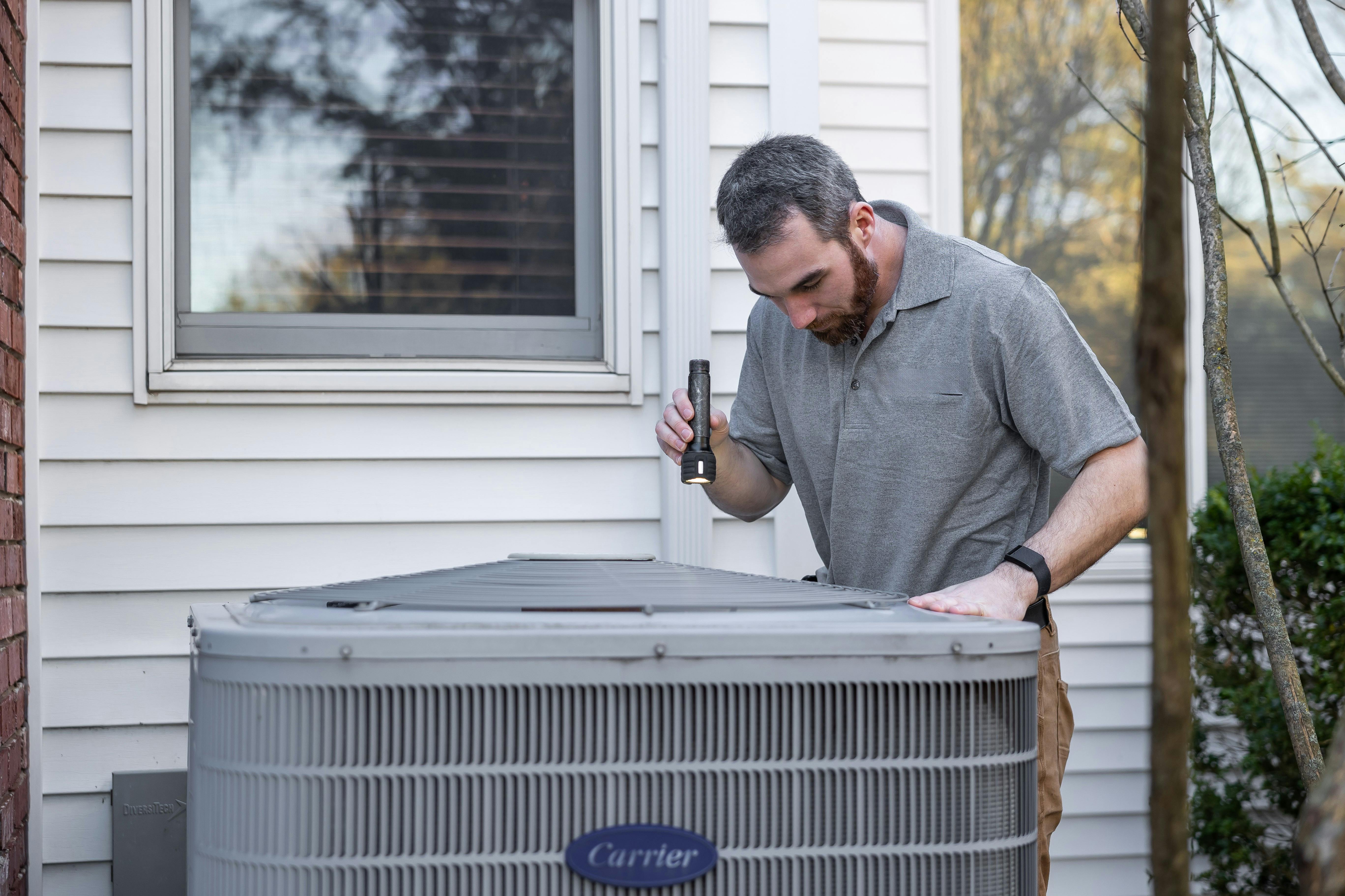 Licensed HVAC contractor repairing air conditioner in Grand Rapids Michigan